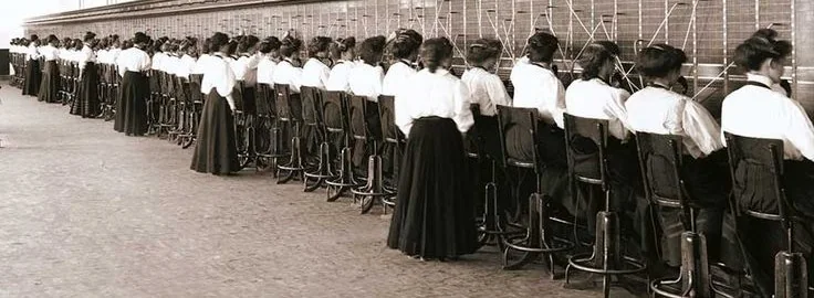 Historische rij telefonistes achter een lange telefooncentrale